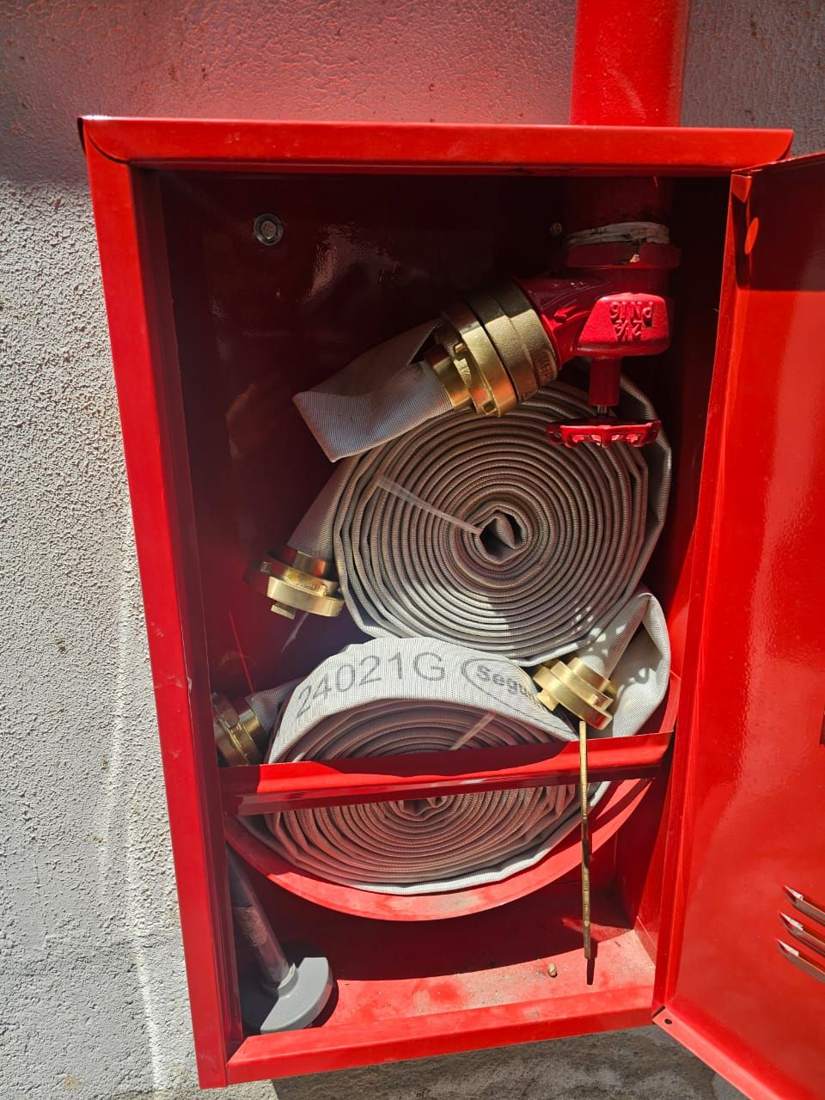 Abrigo de hidrante aberto com mangueira acondicionada